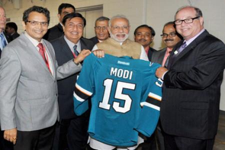 PM Modi holding a sports jersey with his name