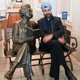 Navtej Sarna sitting next to statue